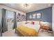 Modern bedroom featuring a blue accent wall, shelving, and natural light from the window at 17382 Bluetrail Ave, Parker, CO 80134