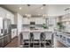 Bright and modern kitchen featuring stainless steel appliances, white cabinetry, and an island with bar seating at 17382 Bluetrail Ave, Parker, CO 80134