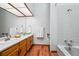 Bathroom featuring double sinks, wood cabinets, and a bathtub/shower at 2275 E 129Th Ave, Thornton, CO 80241