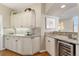 Wet bar with granite countertops, custom cabinets, and under counter wine refrigerator at 19281 E Hinsdale Ln, Centennial, CO 80016