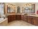 Spacious primary bathroom boasts dual sinks, a soaking tub, and warm wooden cabinets with granite countertops at 19281 E Hinsdale Ln, Centennial, CO 80016