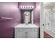 Purple bathroom with white vanity and large mirror, plus a shower visible through the doorway at 19281 E Hinsdale Ln, Centennial, CO 80016