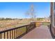 Spacious wooden deck with dark railing, offering stunning views of the open green space at 19281 E Hinsdale Ln, Centennial, CO 80016