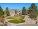 Beautiful brick two-story home with an arched entry and mature landscaping on a sunny day at 19281 E Hinsdale Ln, Centennial, CO 80016