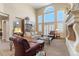 Bright living room with tall windows, a fireplace, and comfortable sofas and seating at 19281 E Hinsdale Ln, Centennial, CO 80016