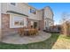 Brick and siding home with a stone patio and wooden furniture on the back of the home at 19281 E Hinsdale Ln, Centennial, CO 80016