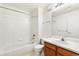 Bathroom featuring a white tiled bathtub, a toilet, and a wooden sink at 5714 N Gibralter Way # 5-306, Aurora, CO 80019