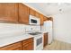 Kitchen featuring white appliances, wooden cabinets, and a laminate countertop at 5714 N Gibralter Way # 5-306, Aurora, CO 80019