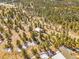 Wide aerial view showcasing a secluded home nestled among dense trees at 13012 S Wamblee Valley Rd, Conifer, CO 80433