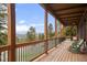 Covered deck with mountain views and wooden floors at 13012 S Wamblee Valley Rd, Conifer, CO 80433