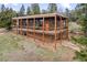 The exterior features a house on stilts with wood columns and orange front door at 13012 S Wamblee Valley Rd, Conifer, CO 80433