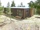 Charming home exterior with wood siding, a wooden porch, and a stone chimney at 13012 S Wamblee Valley Rd, Conifer, CO 80433