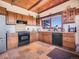 Spacious kitchen featuring custom cabinets, black appliances, and a cozy atmosphere at 13012 S Wamblee Valley Rd, Conifer, CO 80433