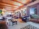 Open-concept living room features wood-beamed ceiling, hardwood floors, and stunning views at 13012 S Wamblee Valley Rd, Conifer, CO 80433