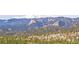 Scenic mountain view with snow-capped peaks and lush green forests in a desirable location at 13012 S Wamblee Valley Rd, Conifer, CO 80433