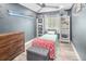 Bedroom with ample natural light, dark-blue walls, hardwood floors, white bookshelves, and cozy furniture at 9677 Castle Ridge Cir, Highlands Ranch, CO 80129