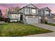 Charming two-story home features a well-manicured lawn, two-car garage, and inviting front entrance at 9677 Castle Ridge Cir, Highlands Ranch, CO 80129