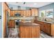 Well-lit kitchen featuring wooden cabinets, stainless steel appliances, and a center island at 9677 Castle Ridge Cir, Highlands Ranch, CO 80129