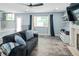 Well-lit living room features gray couch, fireplace, TV, and outside view with curtains at 9677 Castle Ridge Cir, Highlands Ranch, CO 80129