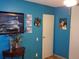 Blue bedroom with a wooden accent table and framed pictures at 1227 S Uvalda St, Aurora, CO 80012