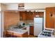 Galley kitchen with wood cabinets and white appliances at 1227 S Uvalda St, Aurora, CO 80012