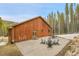 Wood home with stamped concrete patio, outdoor furniture, and fire pit in wooded setting at 79 Beaver Rd, Idaho Springs, CO 80452