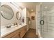 Bathroom featuring double sinks, granite counters, and tiled walk-in shower at 537 N Logan St, Denver, CO 80203