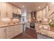 White kitchen featuring stainless steel appliances, granite countertops, wood floors, and mosaic backsplash at 537 N Logan St, Denver, CO 80203