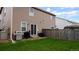 Well-maintained backyard with green grass, a wooden fence, and a grill for outdoor cooking at 765 Mockingbird St, Brighton, CO 80601