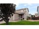 Charming two-story home with a well-maintained lawn, attached garage, and American flag on the front porch at 765 Mockingbird St, Brighton, CO 80601