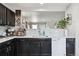 Well-equipped kitchen with dark cabinets, a white dishwasher, and a stylish backsplash at 765 Mockingbird St, Brighton, CO 80601