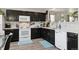 Updated kitchen featuring white appliances, dark cabinets, and a stylish tile backsplash at 765 Mockingbird St, Brighton, CO 80601
