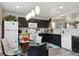 Bright eat-in kitchen featuring dark cabinets, white appliances, and pendant lighting at 765 Mockingbird St, Brighton, CO 80601