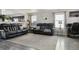 Spacious living room with gray wood floors, black leather sofas, and bright windows at 765 Mockingbird St, Brighton, CO 80601