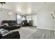 Bright living room featuring gray wood floors, black leather seating, and natural light at 765 Mockingbird St, Brighton, CO 80601