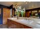 Bathroom with double sinks, stone counters, modern fixtures, and dark colored walls at 31332 Island Dr, Evergreen, CO 80439