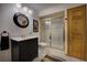 Bathroom featuring a tiled shower with gold trim and a sleek black vanity at 31332 Island Dr, Evergreen, CO 80439