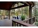 Spacious covered deck featuring a dining area, wood flooring, and serene outdoor views at 31332 Island Dr, Evergreen, CO 80439