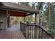 Exterior view of wooden deck with overhead cover, railing, and mature landscaping at 31332 Island Dr, Evergreen, CO 80439