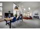 Open-concept dining area with modern table, chairs, vaulted ceilings, and views of the living room at 31332 Island Dr, Evergreen, CO 80439