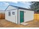 Newly built backyard shed with fresh white paint, contrasting trim, and a vibrant green door adds backyard storage at 3242 N Albion St, Denver, CO 80207