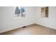 Bright bedroom featuring wood floors, white walls, and a window providing ample natural light at 3242 N Albion St, Denver, CO 80207