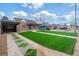 Charming brick home featuring an artifical lawn and a welcoming covered porch and an attached carport at 3242 N Albion St, Denver, CO 80207