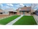 Charming brick home featuring an artifical lawn and a welcoming covered porch, enhancing curb appeal at 3242 N Albion St, Denver, CO 80207