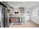 Modern kitchen with stainless steel appliances and gray cabinets, with backsplash, and access to outdoor area at 3242 N Albion St, Denver, CO 80207