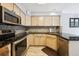 Well-lit kitchen featuring stainless steel appliances, stylish backsplash, granite counters, and wood-look floors at 1124 E 130Th Ave # C, Thornton, CO 80241