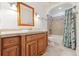 Bathroom with warm wood vanity, mirror, and tiled shower with tub combination at 2492 S Yarrow St, Lakewood, CO 80227