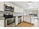 Well-lit kitchen featuring stainless steel appliances, white cabinets, and a sliding glass door to the outdoor area at 2492 S Yarrow St, Lakewood, CO 80227
