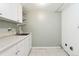 Bright laundry room featuring ample cabinet space, stainless steel sink, and tile flooring at 2492 S Yarrow St, Lakewood, CO 80227