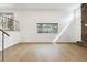 Unstaged living room with a stone fireplace, large window, and hardwood floors at 2492 S Yarrow St, Lakewood, CO 80227